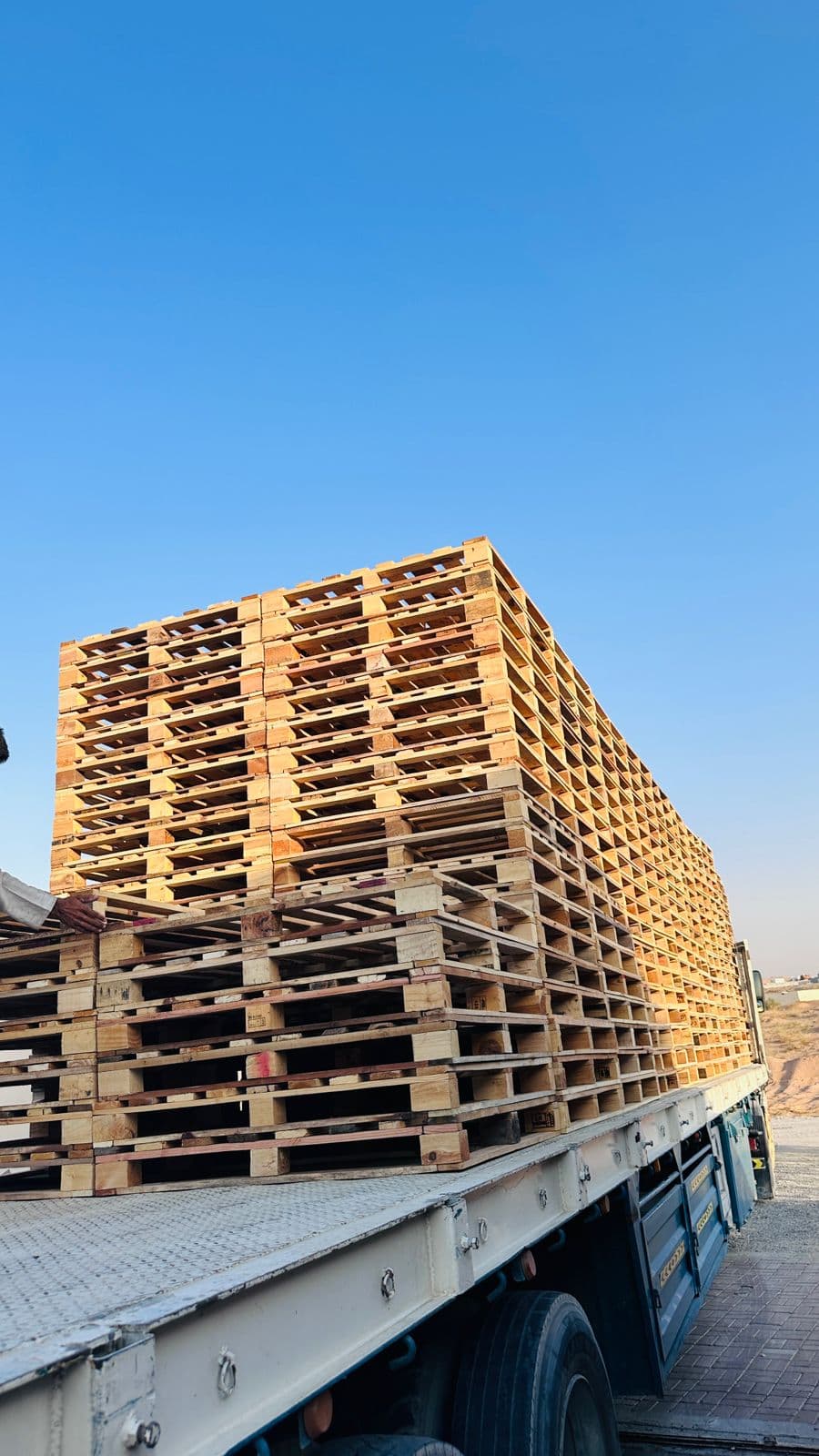 A trailer loaded high with strapped wooden pallets ready for a long-haul delivery run
