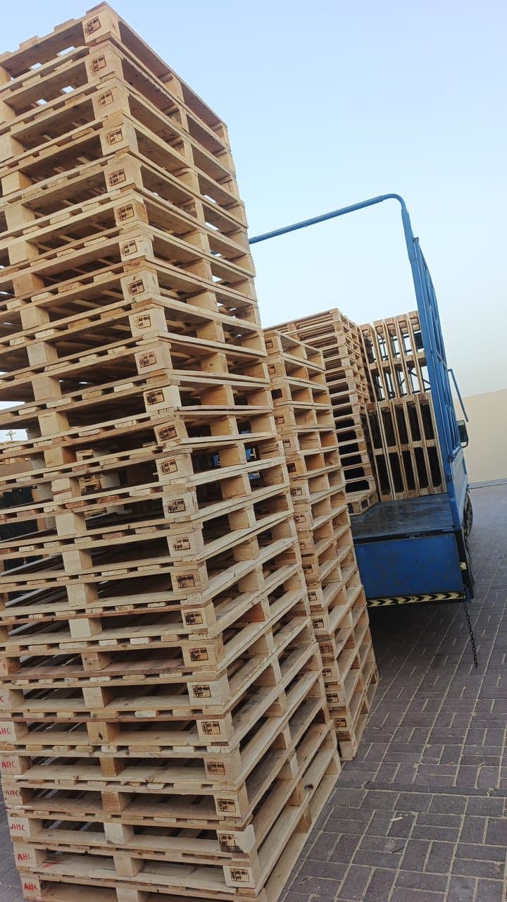 Stamped used pallets being loaded onto a flatbed truck for delivery
